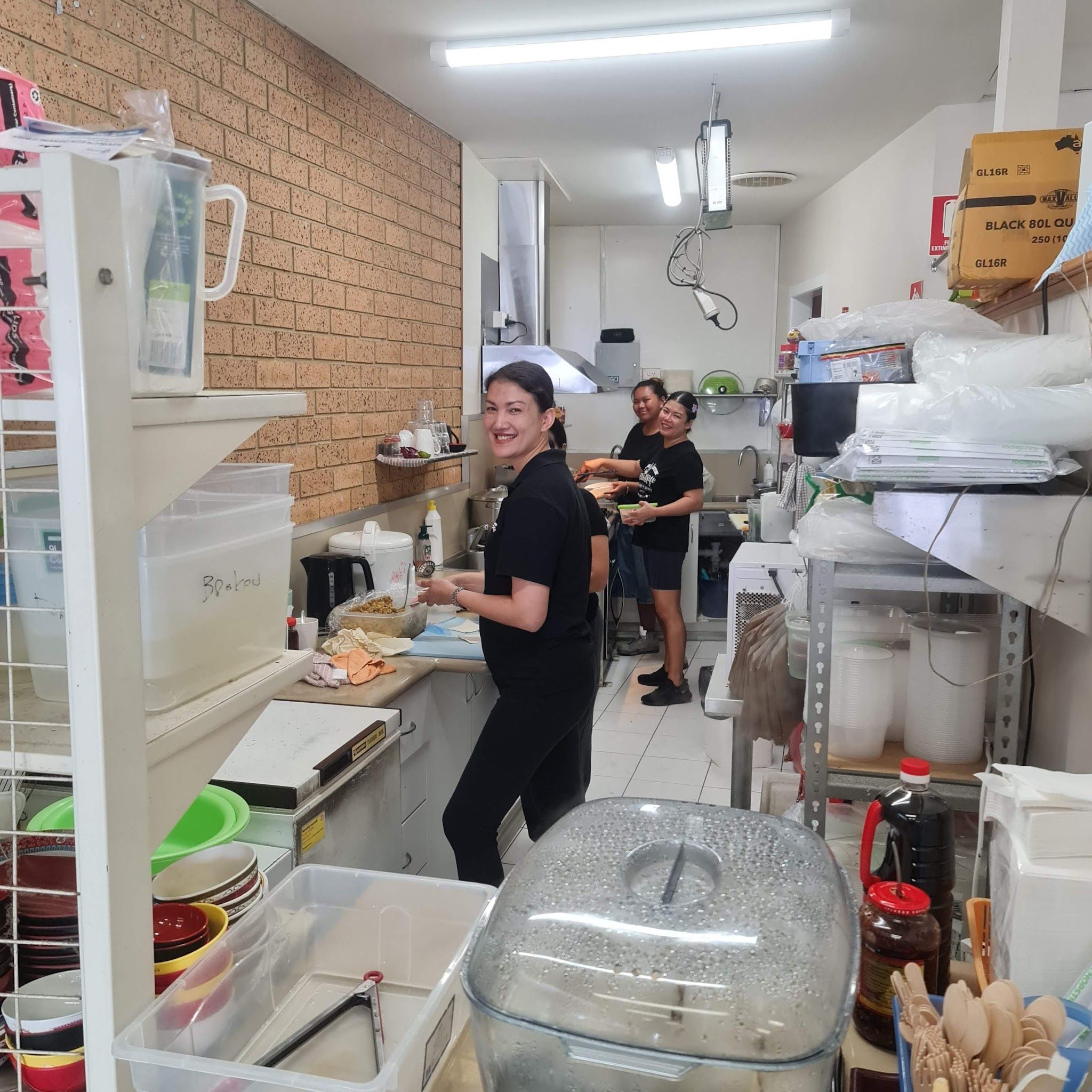 Two smiling staff members working in the San Remo Asian Grocery kitchen